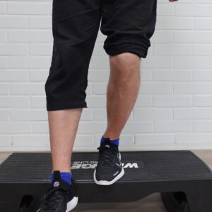 Fysioterapeutti seuraa asiakkaan polven linjausta portaissa noustessa