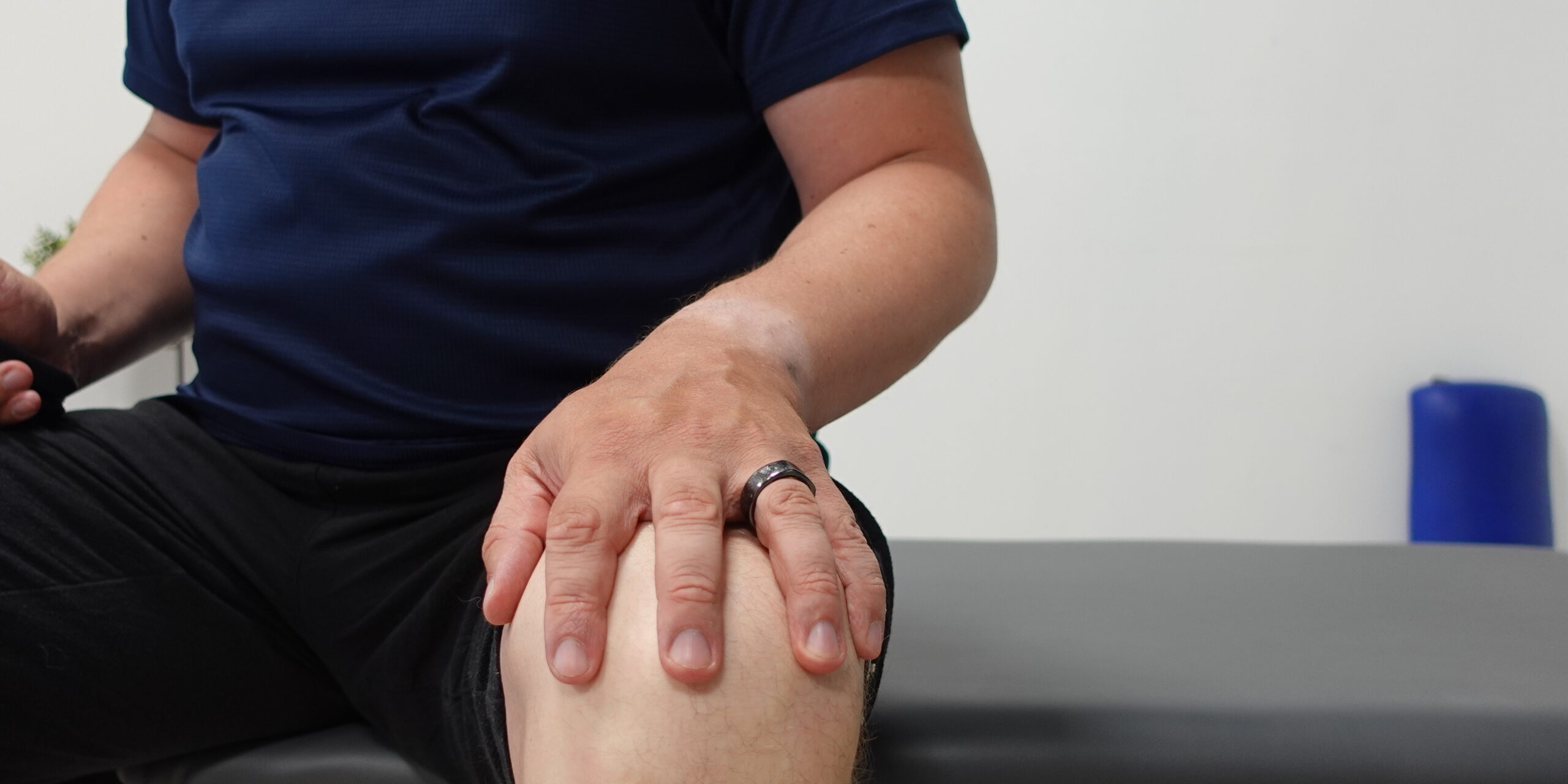 Polvikivun tutkiminen fysioterapiassa Joensuussa Fysioterapeutti Teppo Holopainen tunnustelee omaa polveaan sormilla havainnollistaen polven tutkimista fysioterapiavastaanotolla Joensuussa