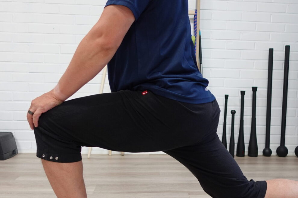 Fysioterapeutti näyttää, miltä lonkan liikerajoitus voi näkyä ja ohjaa liikkuvuutta lisäävää harjoitetta vastaanotolla Joensuussa.