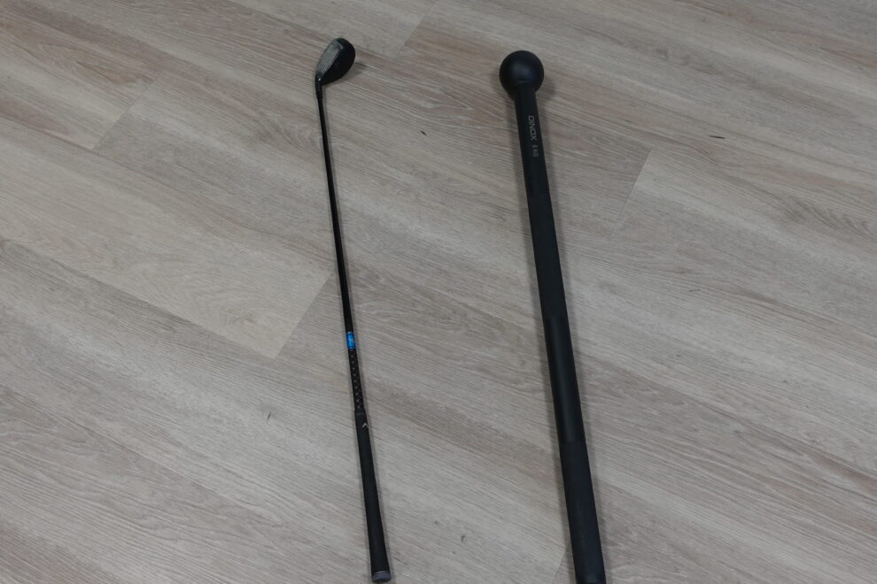 Golfmaila ja voimaleka vierekkäin lattialla symboloimassa harjoittelun kuormitusta ja palautumisen tarvetta golf-fysioterapiassa Joensuussa.