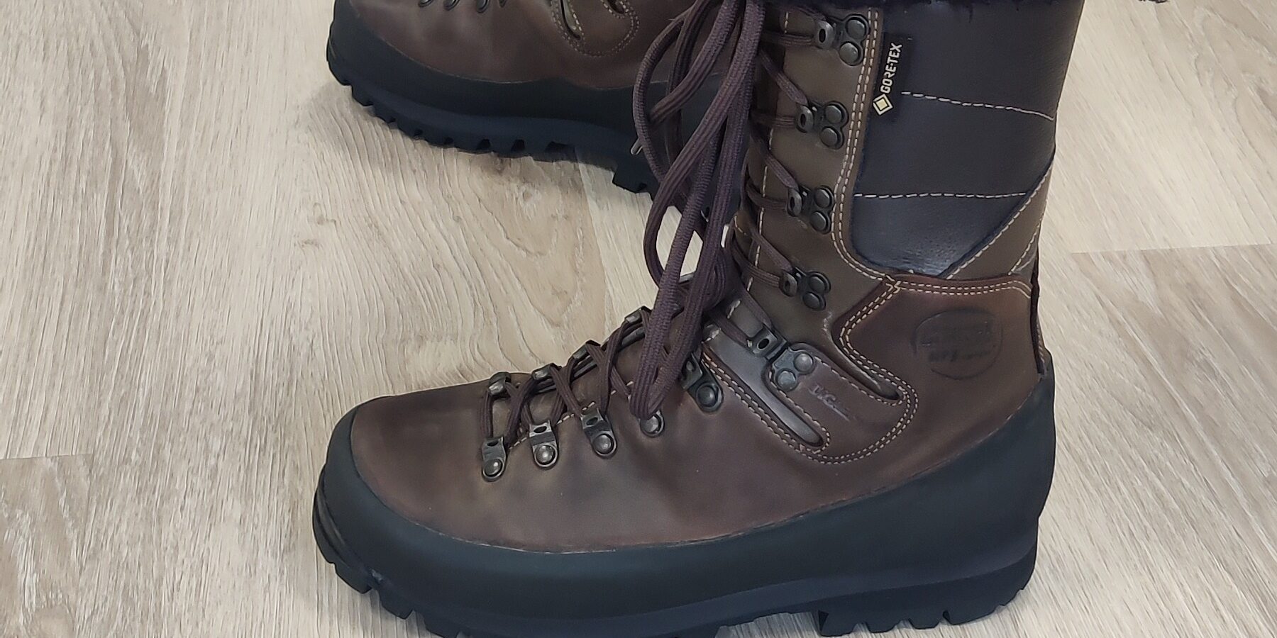 Vaelluskengät ja alaraajan kuormituksen tasaaminen tukipohjallisilla Joensuussa Henkilö seisoo Gore-Tex vaelluskengät jalassa Reijolan Fysioterapian vastaanotolla Joensuussa havainnollistaen aktiivikäytön alaraajaan kohdistamaa kuormitusta
