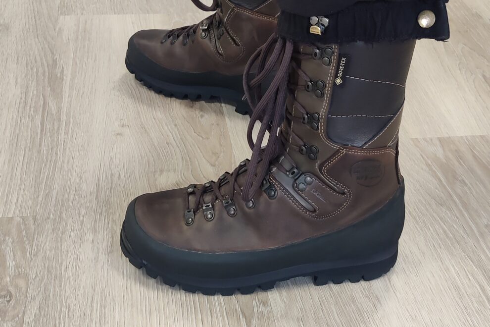 Henkilö seisoo Gore-Tex vaelluskengät jalassa Reijolan Fysioterapian vastaanotolla Joensuussa havainnollistaen aktiivikäytön alaraajaan kohdistamaa kuormitusta