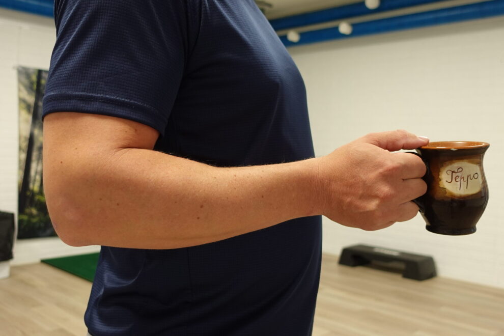 Kahvikupin nostaminen aiheuttaa kipua kyynärpään ulkosivulla – tenniskyynärpää fysioterapia Joensuu.