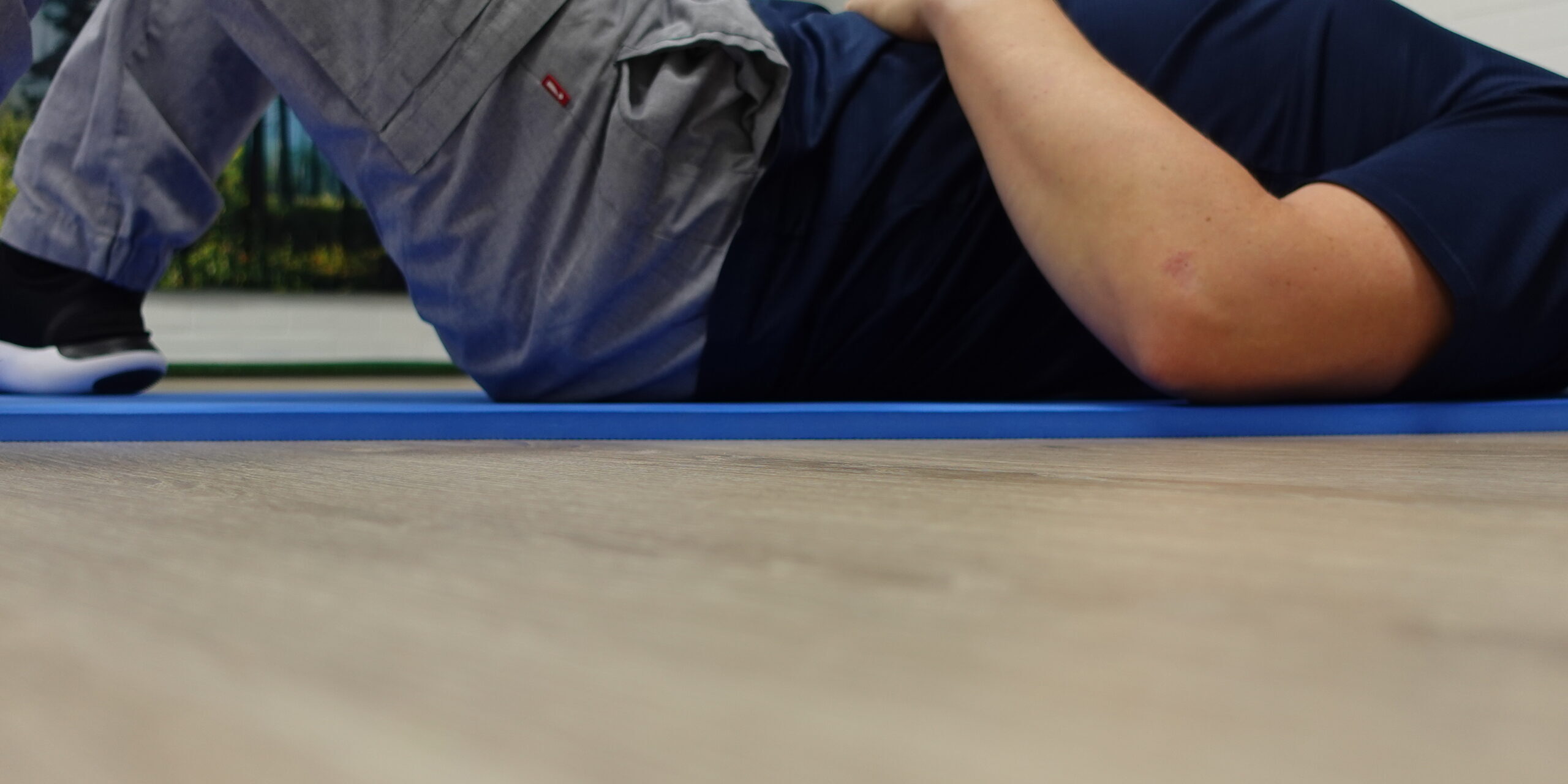 Selinmakuulla oleva mies tekee lantionpohjan jännitysharjoitetta, käsi vatsan päällä. Harjoitus tukee hermoston rauhoittumista ja kehon tasapainoa fysioterapiassa Joensuussa.