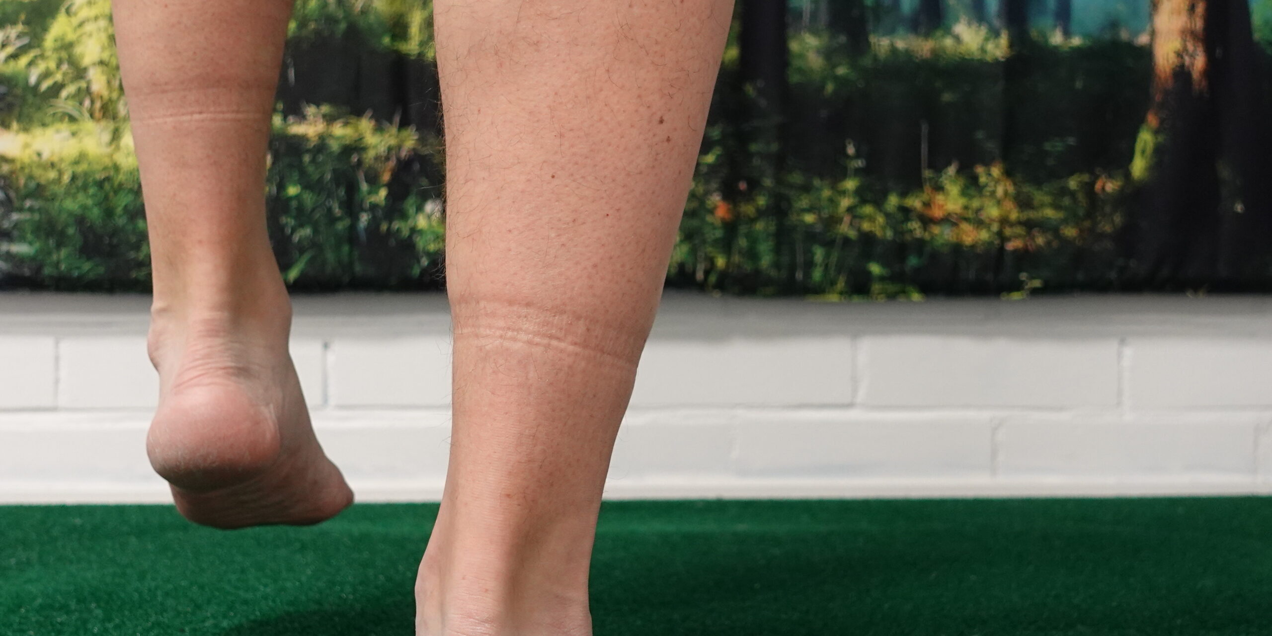 Henkilö tasapainoilee pehmeällä alustalla kantapäiden tasolta kuvattuna. Kuva havainnollistaa jalkaterän ja nilkan hallinnan merkitystä tasapainossa liukkailla keleillä.