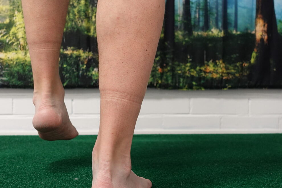 Henkilö tasapainoilee pehmeällä alustalla kantapäiden tasolta kuvattuna. Kuva havainnollistaa jalkaterän ja nilkan hallinnan merkitystä tasapainossa liukkailla keleillä.