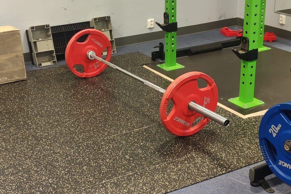 tanko ja levypainot kuntosalilla, kuvaamassa lähiliikuntapaikkojen merkitystä toimintakyvyn ja terveyden ylläpidossa