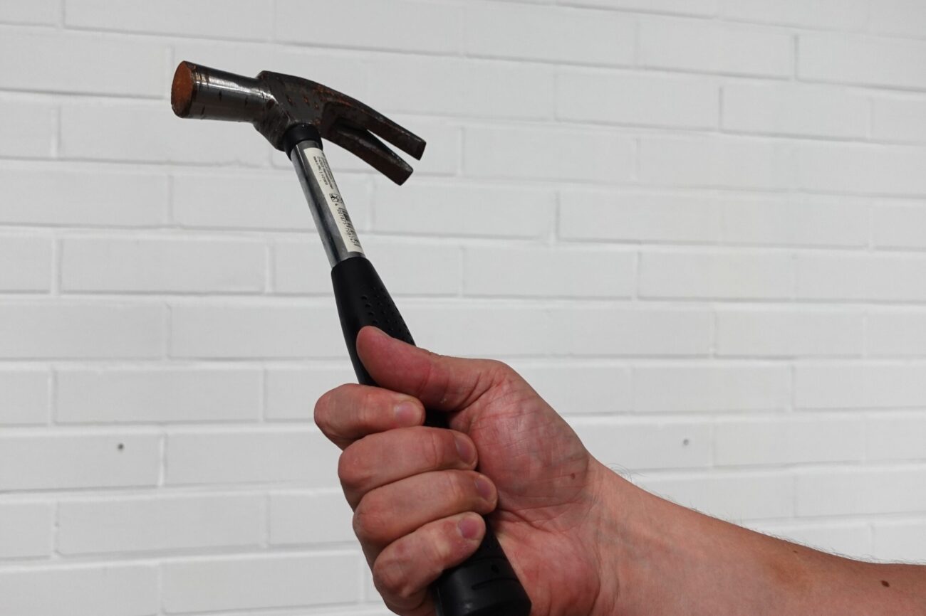 Käsi pitää vasaraa – käsien puutuminen voi liittyä toistuvaan kuormitukseen