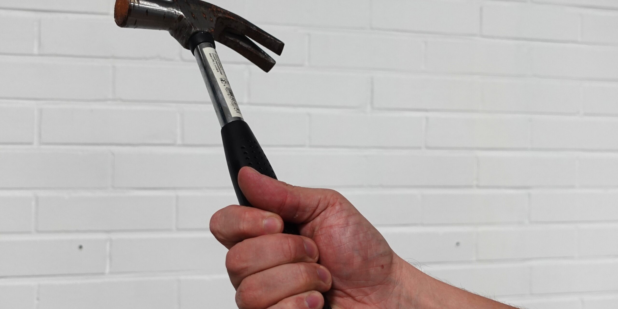 Käsi pitää vasaraa – käsien puutuminen voi liittyä toistuvaan kuormitukseen